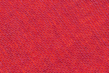 Fototapeta premium Detailed view of a woven fabric in bright red color showing patterns and texture in natural light during the daytime