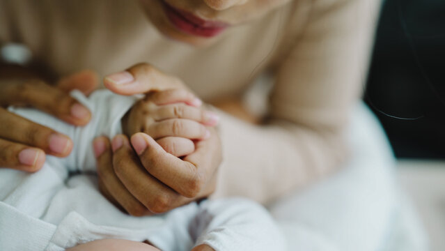 Soft hands cradle a tiny hand. Gentle touch conveys care and comfort. Warmth radiates in this tender moment. Ideal for parenting, health, or emotional support themes. Emotionally rich, yet simple