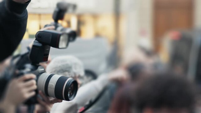 Group of paparazzi photographers taking pictures with flashes