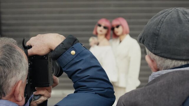 Photographers taking pictures of twin models with pink hair