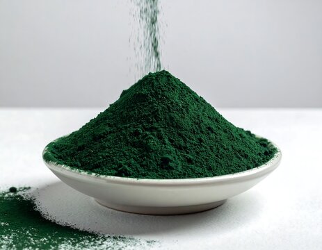 green spirulina powder pouring into bowl, healthy superfood ingredient concept