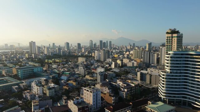 Vietnam, Da Nang Da Nang Skyline At Golden Sunrise Sweeping Aerial View Of Modern Highrises, Dense Residential Blocks, Prominent Rounded Tower, Distant Mountains, Soft Haze, Warm Light,