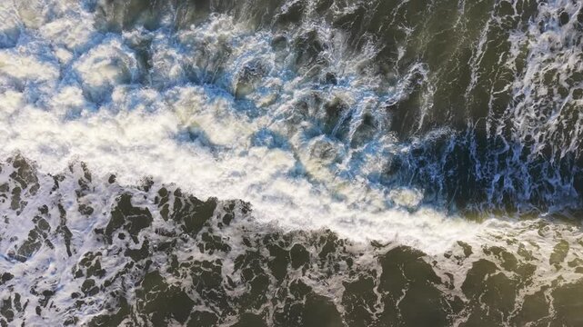 Aerial Foamy Ocean Surf Closeup Showing Chaotic White Foam, Dark Green Water, Swirling Eddies, Powerful Turbulence And Textured Patterns Ideal For Abstract Backgrounds And Coastal Survey