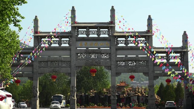 Traditional Chinese Stone Archway with Flags and Lanterns