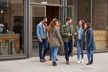Fototapeta premium Friends walking together outside an urban building entrance