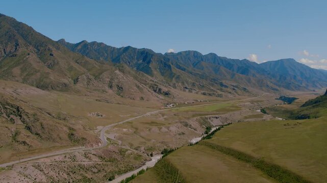 Drone footage of the confluence of the Chuya and Katun rivers in the Altai Republic, Russia, with mountain ridges, winding riverbed and open steppe valley