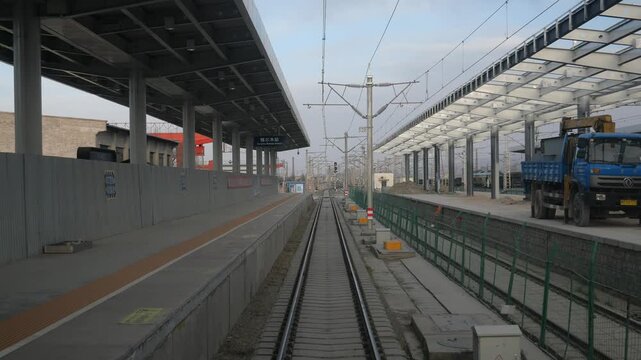 Golmud Station railway platform under construction with tracks and overhead wires