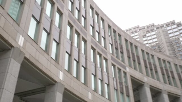Low Angle View Of Tokyo Metropolitan Government Building's Curved Assembly Hall In Shinjuku, Tokyo, Japan. handheld panning shot