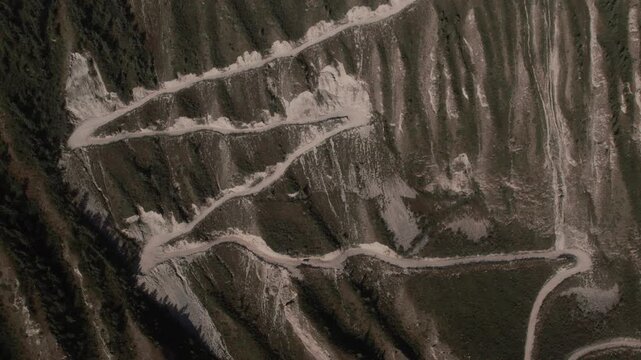 Top down aerial footage of the winding gravel road with sharp switchbacks on Katu-Yaryk Pass above Chulyshman Valley, Altai Republic, Russia