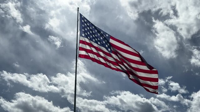 large american flag flapping in the wind against stormy cloudy skies