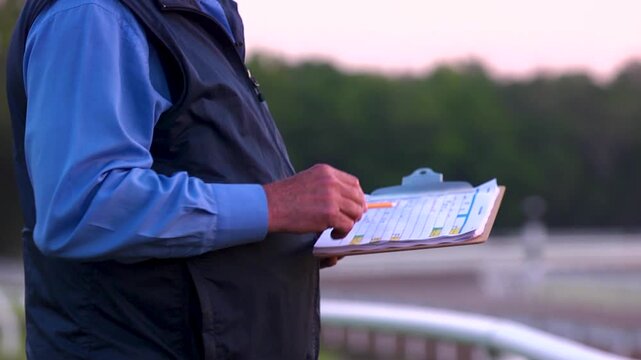 Horse trainer taking notes of horses