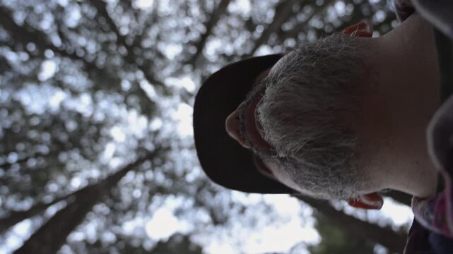 Low angle shot of bearded man exploring dense forest