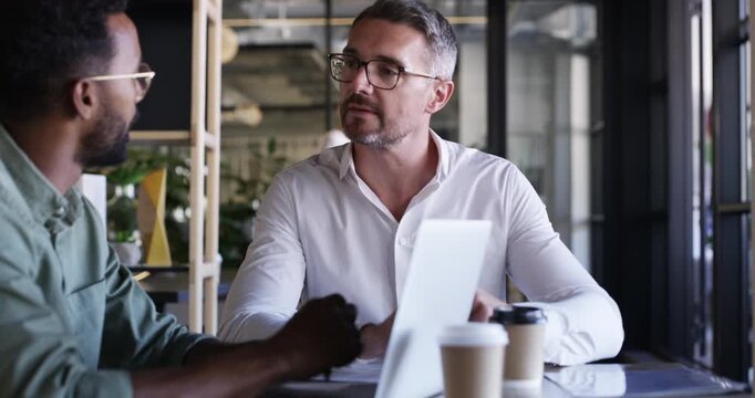 Businessmen, discussion and laptop for meeting at office, feedback and review in training or support. Online research, partnership and mature man for mentor, communication and technology for analysis