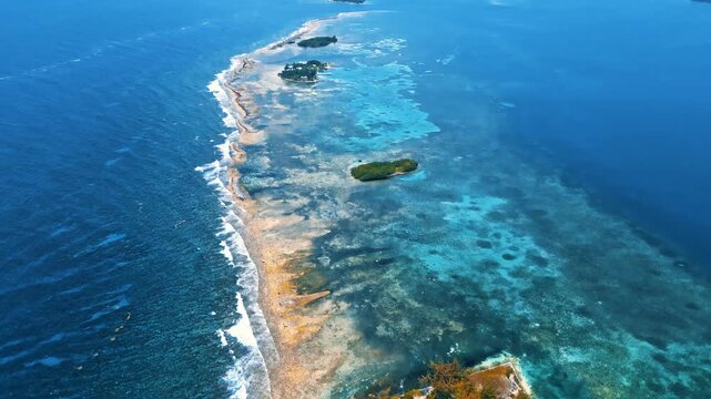 Aerial view of the coral reef and small cays surrounded by turquoise Caribbean waters in Guanaja, Bay Islands Department, Honduras.