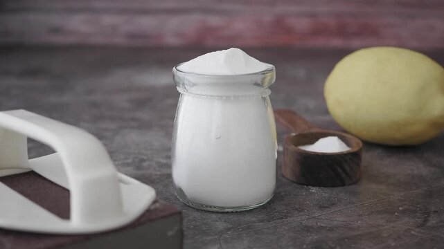 Baking Soda, Lemon, and Cleaning Brush on Countertop