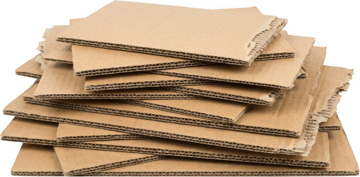 A stack of torn and frayed brown corrugated cardboard sheets revealing their layered structure with wavy internal material paper packaging shipping rough textured pile recyclable