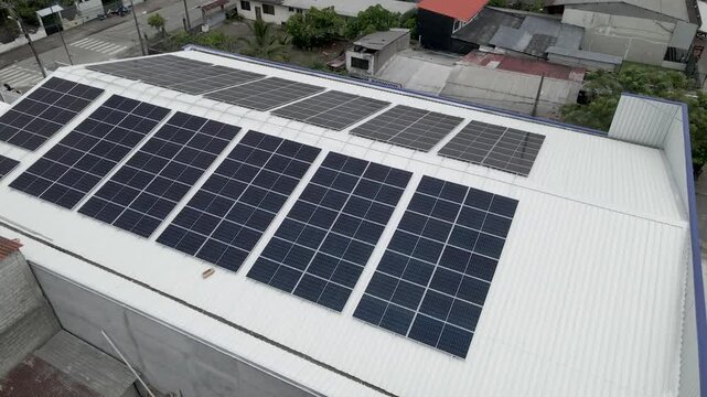 Solar panels installed on industrial warehouse roof generating renewable energy