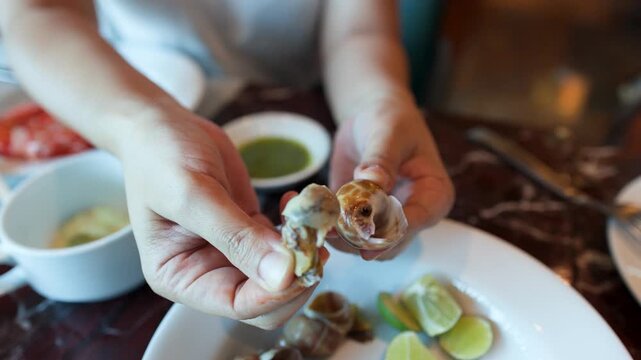 Close Up of Woman Extracting Snail Meat at Seafood Buffet