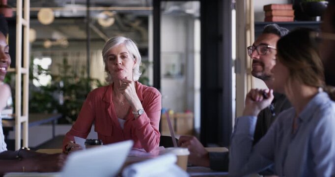 Laptop, mature woman and professional people talking, meeting and journalist consulting on online research story development. Chat, planning web article and chief reporter listen to creative ideas