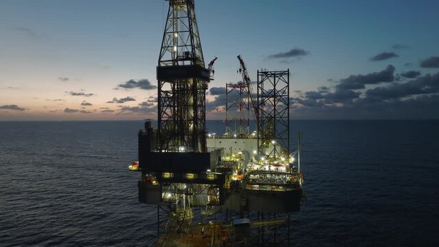 Aerial top view of offshore jack up rig and offshore platform during sunset for oil and gas exploration and production. 