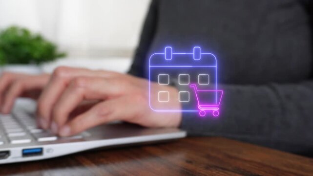 Shopping plan on a calendar. Close-up of a woman's hand working on a computer while pointing to a virtual calendar icon with a shopping cart.