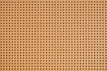 Fototapeta premium Rattan woven texture with interlaced natural fibers and warm earthy tones. Handcrafted organic surface ideal for furniture, panels, wall decor, and tropical interior design.