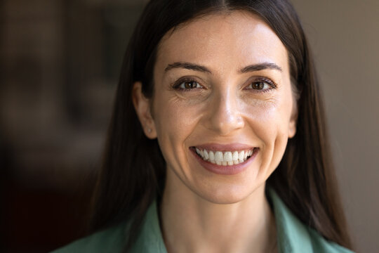 Closeup portrait, front face cropped view of happy adult 30s beautiful woman looking at camera with white-teeth smile, authentic expression, represents natural female beauty, positive mood, wellbeing