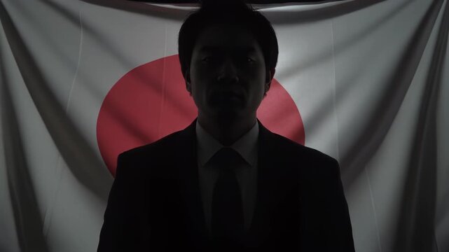 影に沈む国旗と背を向けたビジネスプロフェッショナルが示す経済不透明感
