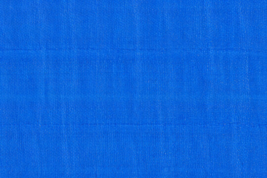 Blue tarpaulin texture with woven plastic pattern and glossy waterproof surface. Ideal for backgrounds, industrial materials, and utility design.