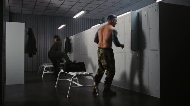 Diverse Group of Three Military Officers communicating informally and Joking While Changing Into Tactical Gear in Functional Locker Room Before Daily Training. Teamwork and Camaraderie in Army.