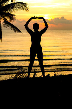 Sunrise with silhouette woman and coconut