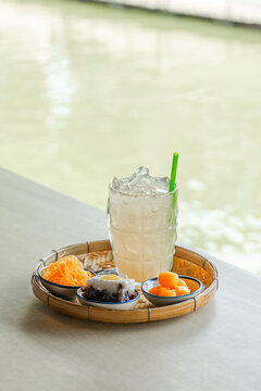 Vertical Thai iced drink with foi thong and longan on bamboo tray Thailand