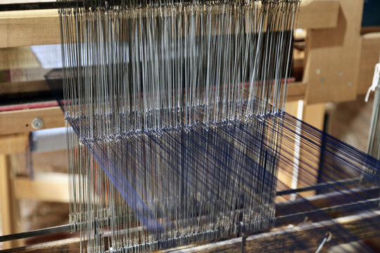 Macro view of warp threads and heddle threads on a weaving loom