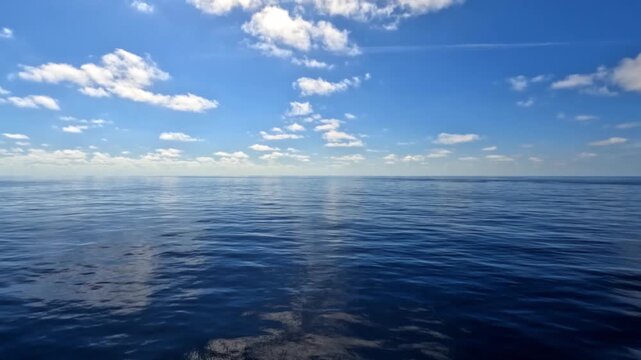 Calm ocean view from a sailing boat, with gentle waves and soft natural light creating a peaceful, relaxing atmosphere. Open sea stretches to the horizon, capturing a sense of freedom