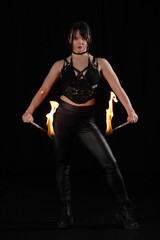 Fototapeta premium Dark fire performance with elegant woman holding flames