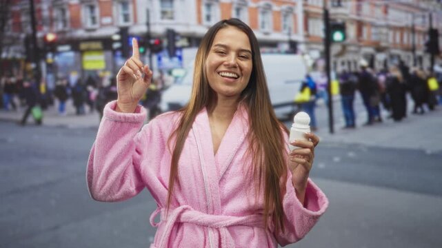Woman in pink bathrobe points finger while holding deodorant on a busy street; joy selfcare morning.