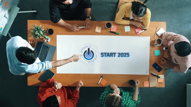 A creative team gathers around a table for a strategic planning meeting aimed at defining goals for the year 2025, showcasing collaboration and innovation in a modern workspace. Raster