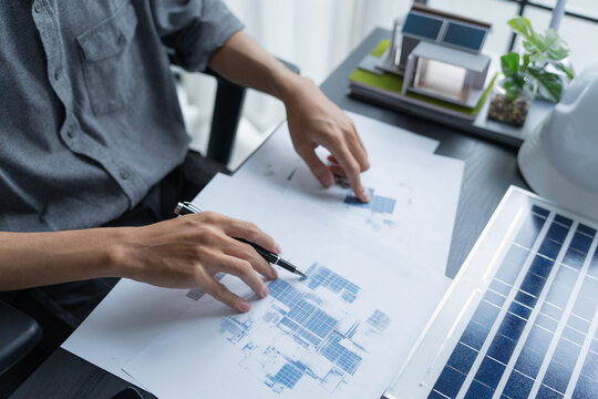 Electrical engineer working on solar panel blueprint sustainable energy