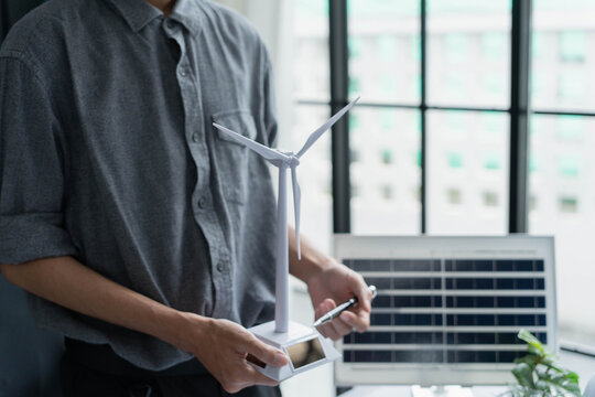 Electrical engineer working with wind turbine model sustainable energy concept