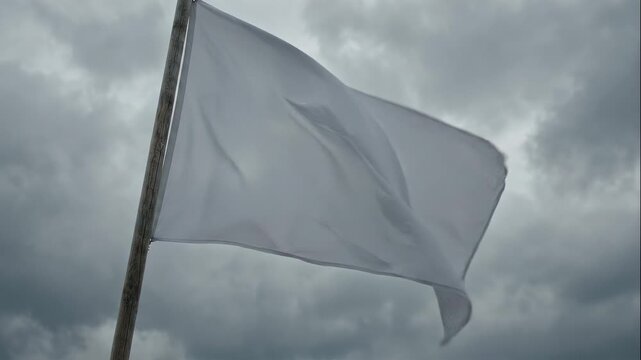 White Flag Waving on Pole Against Cloudy Sky