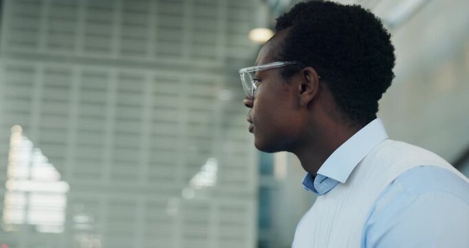 Phone, waiting and black man in city for lift, taxi and transportation to workplace. Business person, hailing app and impatient with schedule, commute and booking for travel service in urban town