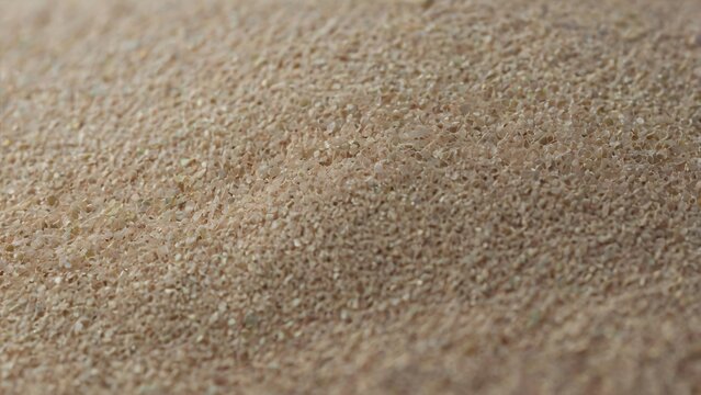 Macro natural sandstone or porous rock or stone surface, earthy beige mineral textured background, gritty architectural texture, organic geological material pattern and tactile granular.