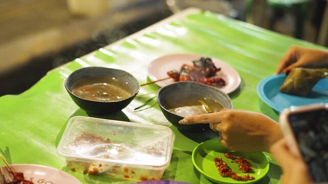Street Vendor Serving Soup to Customers at Local Street Food Stall in Philippines