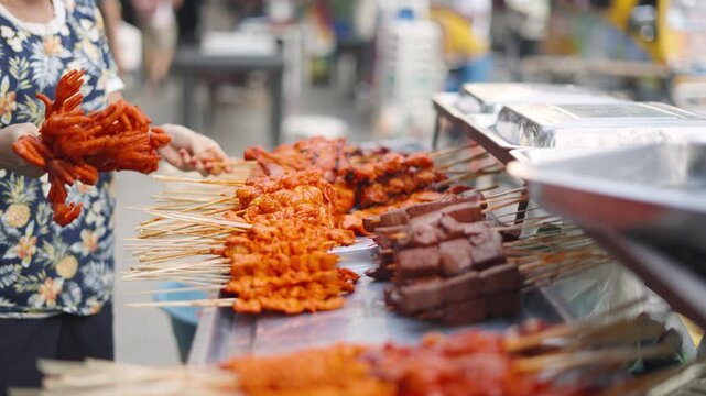 Street Vendor Arranging BBQ Skewers at Food Stall for Sale in Local Market Philippines