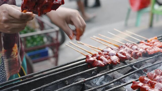 Street Vendor Preparing Chicken Liver BBQ Skewers for Grilling at Local Street Market Philippines