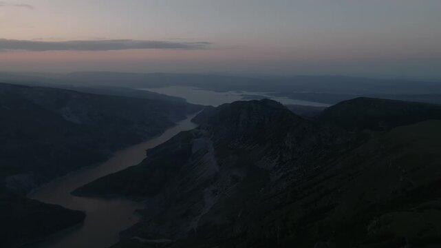 Drone footage of the main Sulak Canyon with a winding river and layered mountain ridges at twilight, Dagestan, Russia, scenic wilderness panorama for travel and nature themes