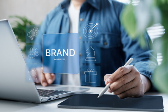 Modern brand awareness strategy concept, digital marketing icons overlay, business Professional using laptop and stylus planning brand awareness, clean workspace, business branding, growth planning