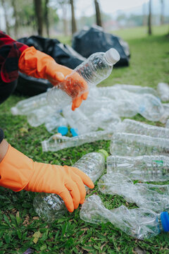 Man picking up plastic waste to clean up at a park	