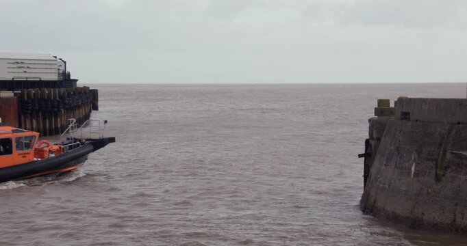 Wide shot of a boat Exiting the entrance to Lowestoft Waveney Dock and Marina