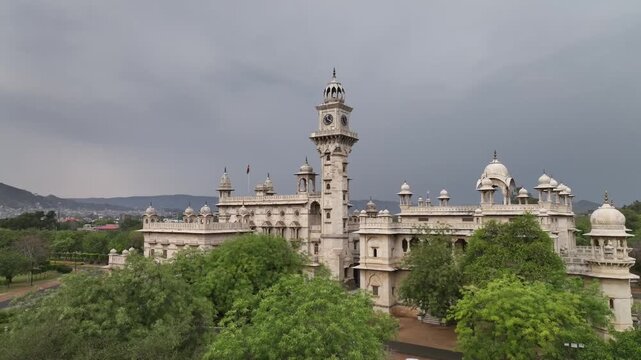 Revealing Mayo college boarding school heritage building surrounded by garden and Aravalli hills, drone shot